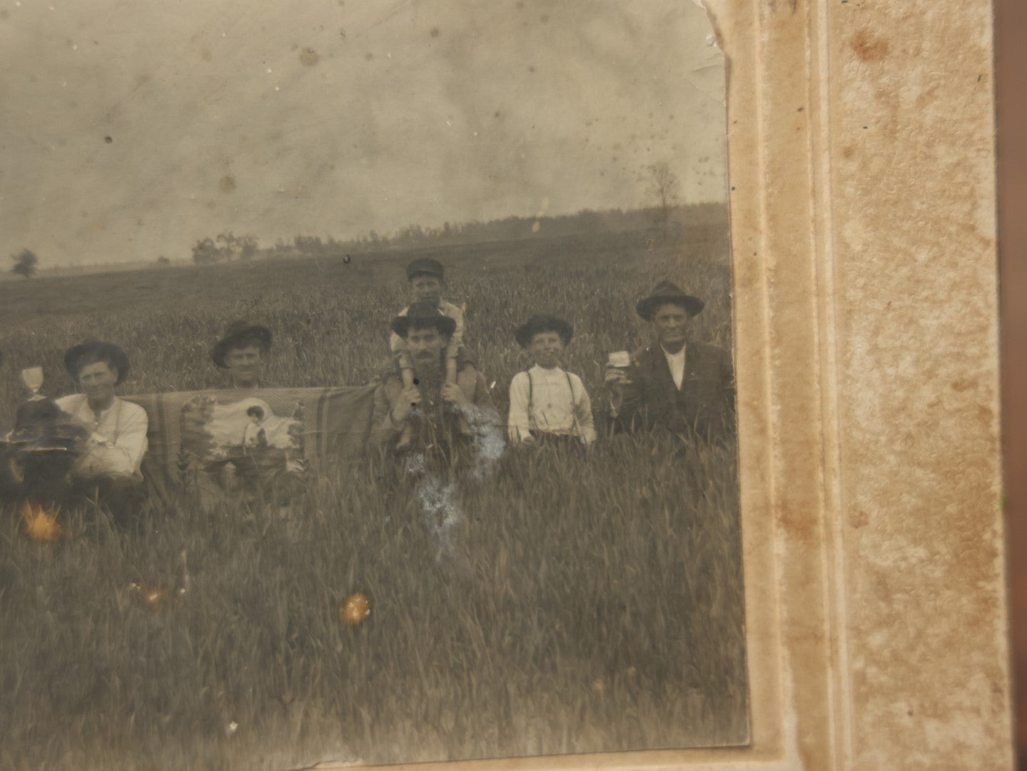 Lot 082 - Antique Boarded Photograph Of A Group Of People In A Tall Grass Field, One Man Holding Pained Banner