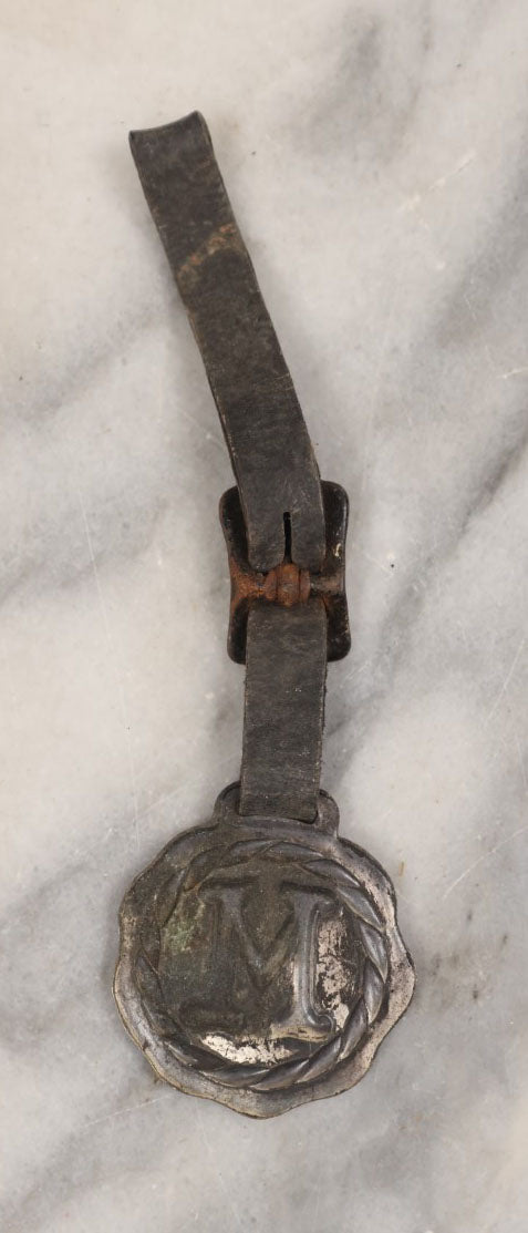 Lot 154 - Single Junk Drawer Finding, Letter "M" Watch Fob With Leather Strap