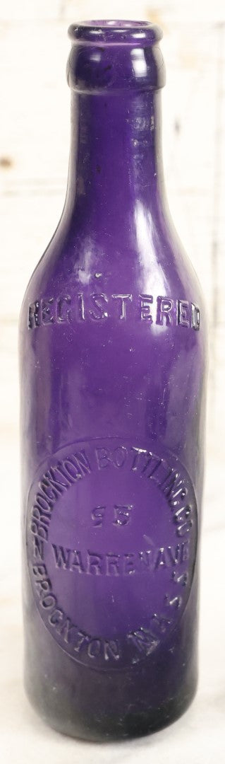 Lot 196 - Grouping Of Three Vintage And Antique Purple Glass Bottles, Including F.W. Kuenhold, Hartford, Connecticut, Sampson Springs Co., South Boston, And Brockton Bottling Co, Massachusetts
