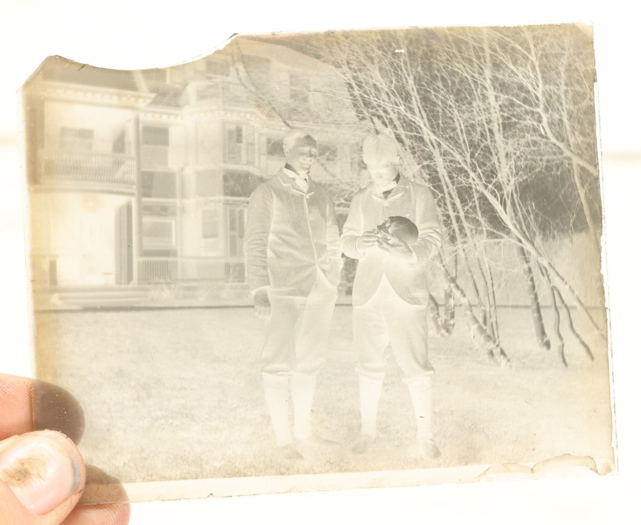 Lot 061 - Single Antique Glass Negative Plate, Man Holding Real Human Skull, With Grinning Man To Left, In Front Of House, Note Edge Cracks (First Photo Is Inverted)