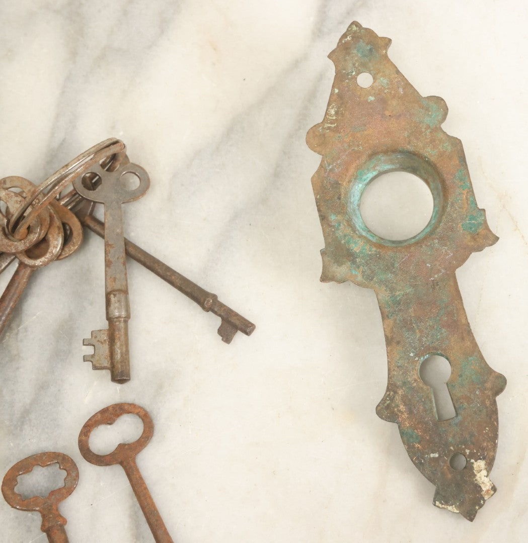 Lot 021 - Grouping Of Ten Antique Skeleton Keys And Two Ornate Antique Doorknob Mount Escutcheons, As Found