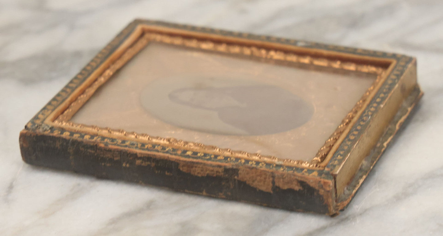 Lot 117 - Antique 1/6th Plate Ambrotype Photograph Of Solemn Woman In Dark Clothing With Patriotic Civil War Era Brass Mat With American Flags, Eagle, Cannon, "E Pluribus Unum" Banner, In Half Case