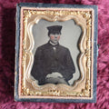 Lot 044 - Antique 9th Plate Ambrotype Of Yound Man In Hat, Dark Clothes, Possible Occupational, In Half Leatherette Case