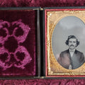 Lot 161 - Quarter Plate Ambrotype Of Handsom Young Man With Interesting Look, Mustache, Unusual Headroom Framing, Near Perfect Condition Large Size Thermoplastic Case With Lay Flat Hinge, Patriotic Shield Brass Mat