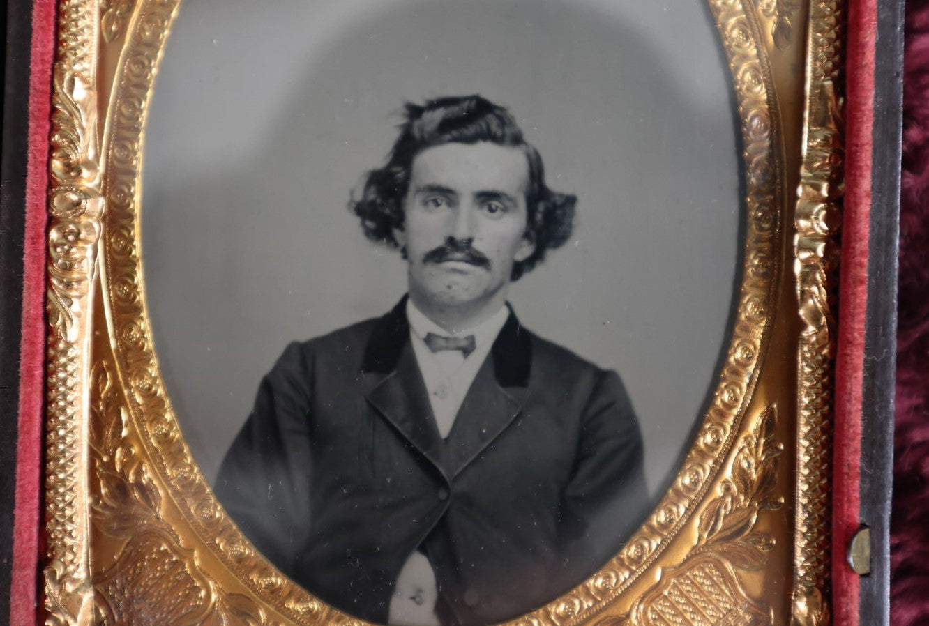 Lot 161 - Quarter Plate Ambrotype Of Handsom Young Man With Interesting Look, Mustache, Unusual Headroom Framing, Near Perfect Condition Large Size Thermoplastic Case With Lay Flat Hinge, Patriotic Shield Brass Mat