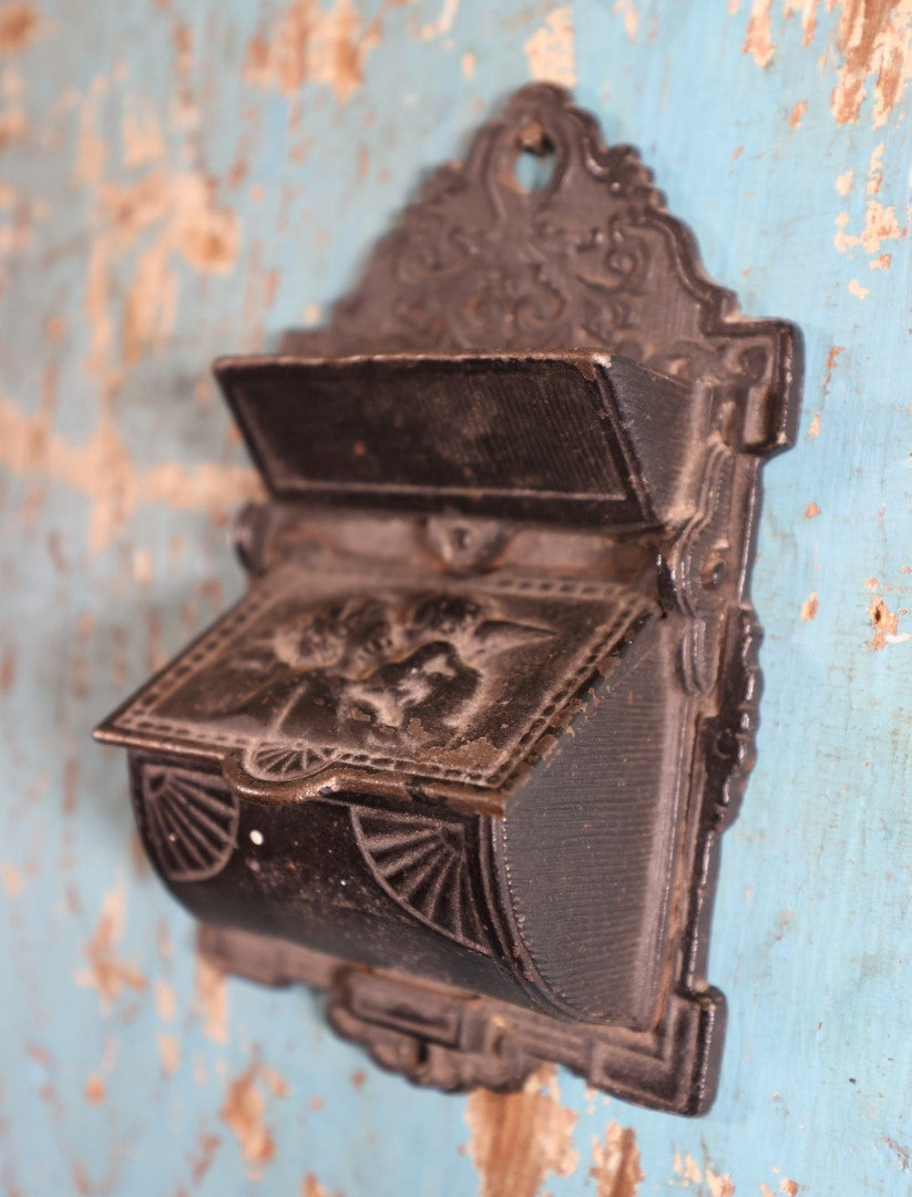 Lot 015 - Antique Venus And Cupid Cast Iron Match Box With Hinged Lid, Match Strike, Marked V.M. Co.