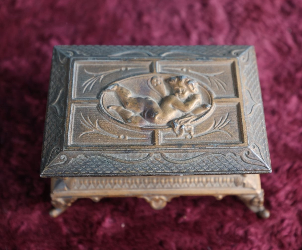 Lot 031 - Antique Pot Metal Match Safe With Cupid Motif, Ornate With Match Strike And Small Box On The Inside, Feet, Etc