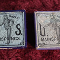 Lot 069 - Pair Of Uncle Sam Watch Main Springs Boxes With Contents
