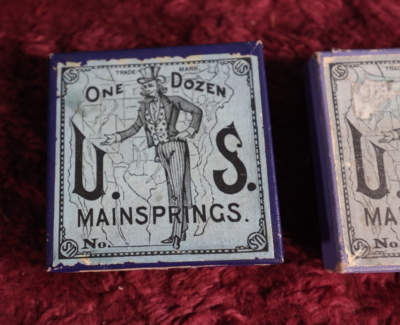 Lot 069 - Pair Of Uncle Sam Watch Main Springs Boxes With Contents