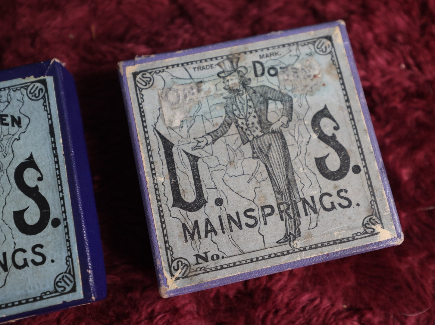 Lot 069 - Pair Of Uncle Sam Watch Main Springs Boxes With Contents