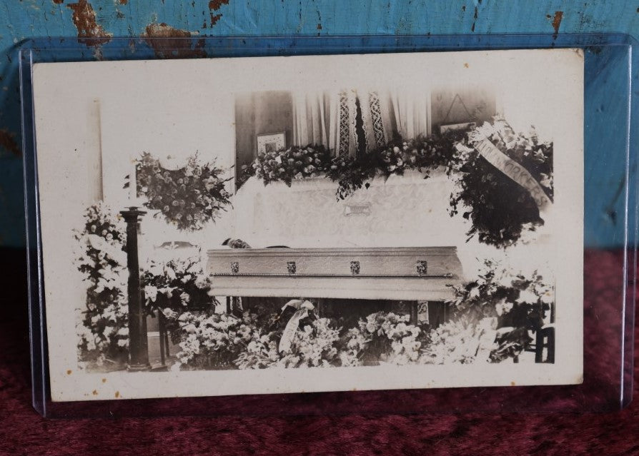 Lot 086 - Antique Real Photo Postcard Rppc Of Man In Coffin, Flower Wreath Says Pillow Workers (?)