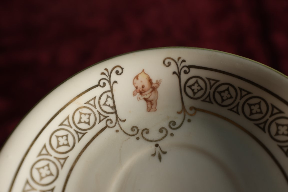 Lot 062 - Antique Royal Munich Kewpie Decorated Tea Cup And Saucer, Rose O'Neill, Marked Bavaria, Note Hairlines In Teacup