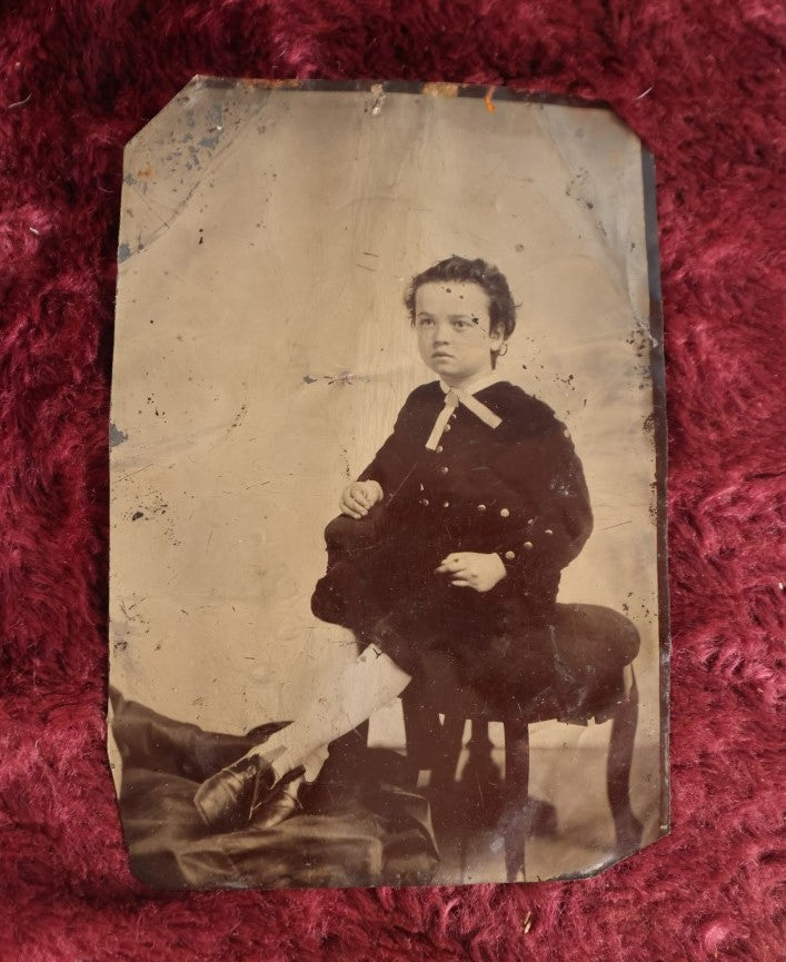 Lot 120 - Quarter Plate Tintype Of Young Boy Sitting On Ottomon, Dents, Wear