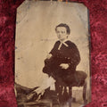Lot 120 - Quarter Plate Tintype Of Young Boy Sitting On Ottomon, Dents, Wear