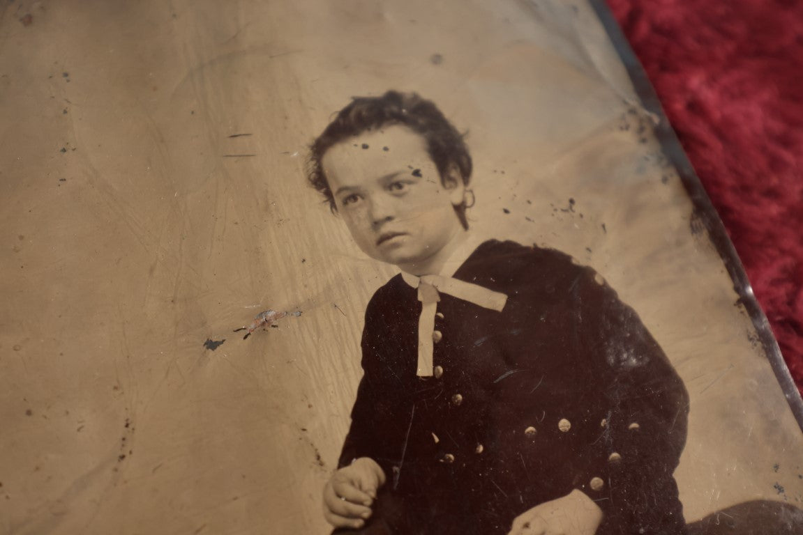 Lot 120 - Quarter Plate Tintype Of Young Boy Sitting On Ottomon, Dents, Wear