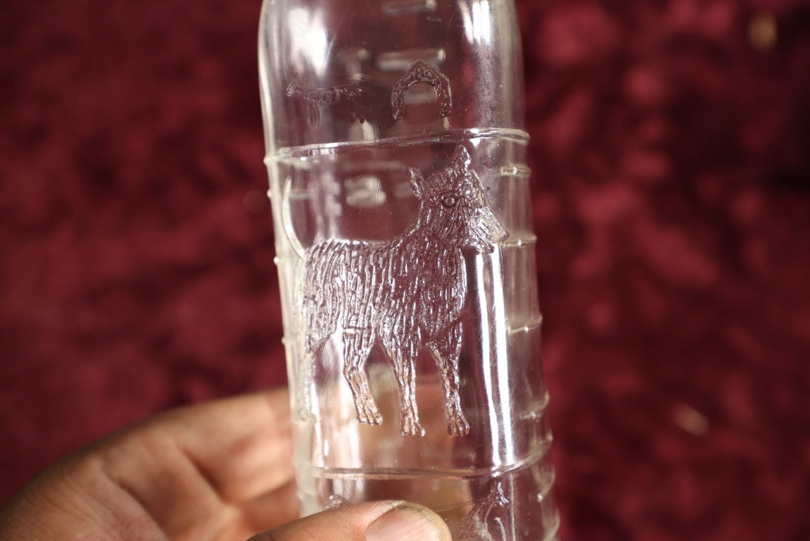 Lot 134 - Antique 8 Ounce Clear Glass Baby Bottle With Embossed Dog, Doghouses