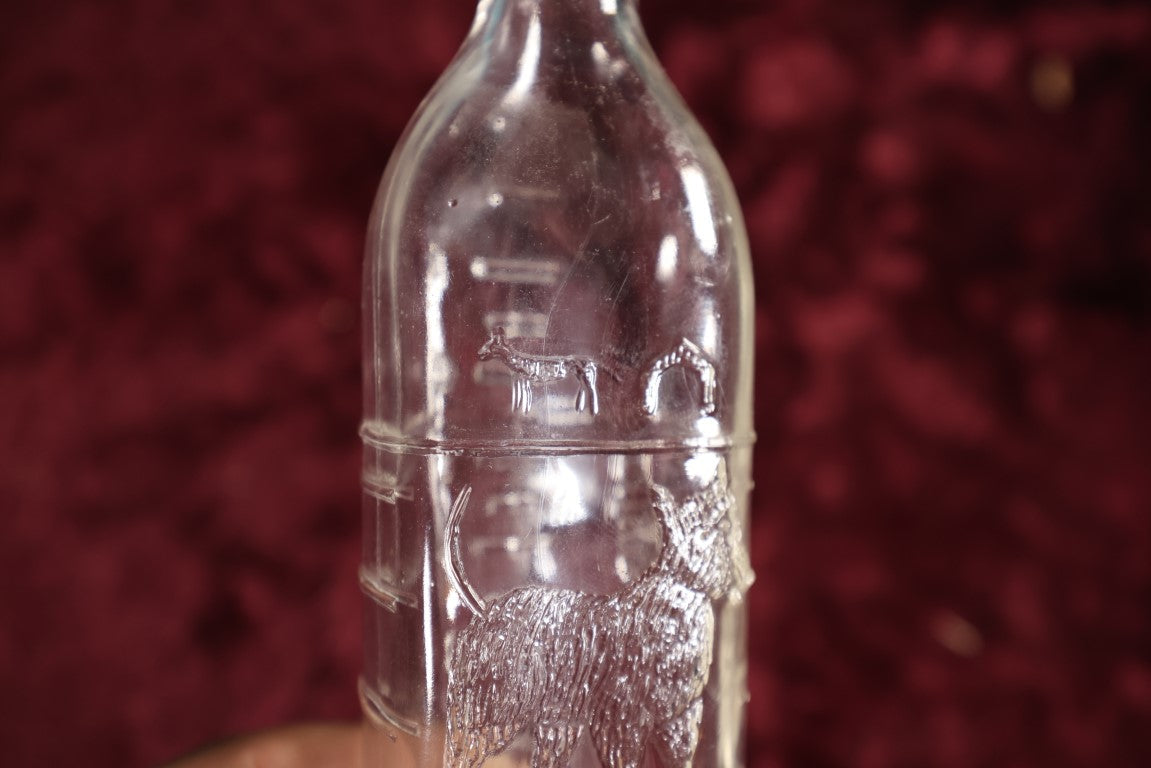 Lot 134 - Antique 8 Ounce Clear Glass Baby Bottle With Embossed Dog, Doghouses