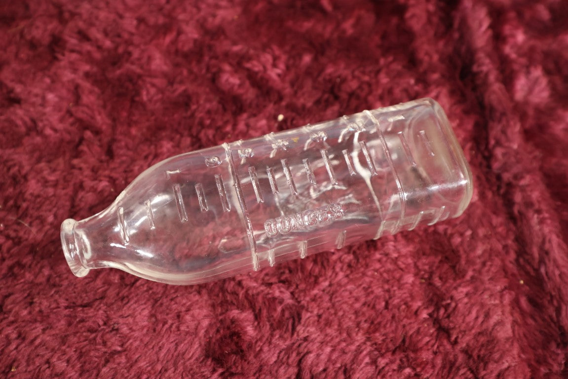 Lot 134 - Antique 8 Ounce Clear Glass Baby Bottle With Embossed Dog, Doghouses