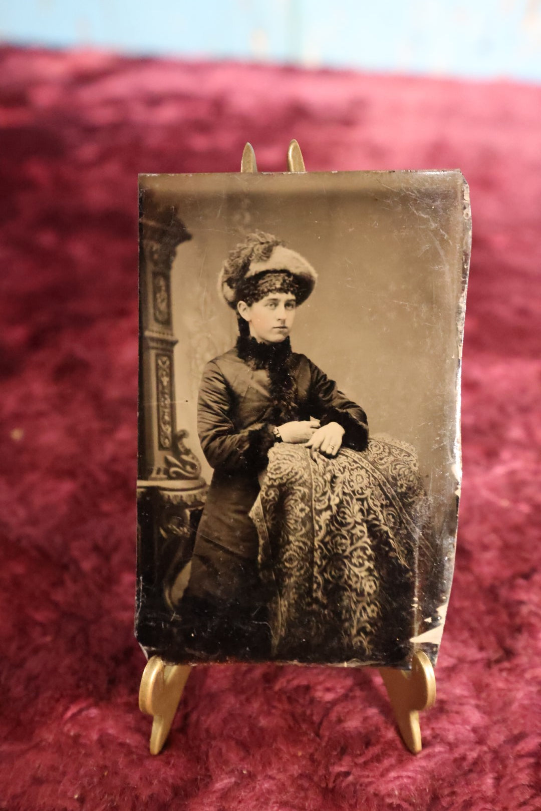 Lot 101 - Tintype - Woman Leaning On Pedestal Covered In Paisley, In Large Fuzzy Hat