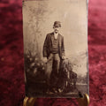 Lot 103 - Tintype - Young Man In Bowler Hat, Suit, Leaning On Chair, Trees Backdrop
