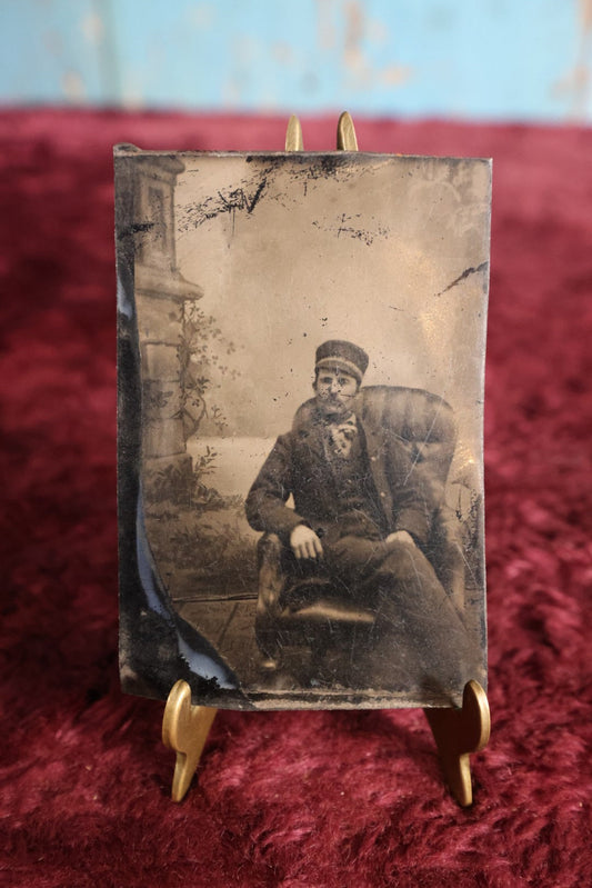 Lot 105 - Tintype - Man In Cap Sitting In Chair With Legs Crossed, Relaxed Posture, Leather Chair