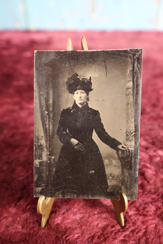 Lot 108 - Tintype - Woman Standing, Dressed In Dark Clothes With Large Decorative Hat, Leather Gloves, Leaning On Pedestal