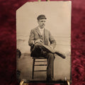 Lot 111 - Tintype - Young Man Sitting With Legs Crossed, Wearing Cap, Smoking Cigar