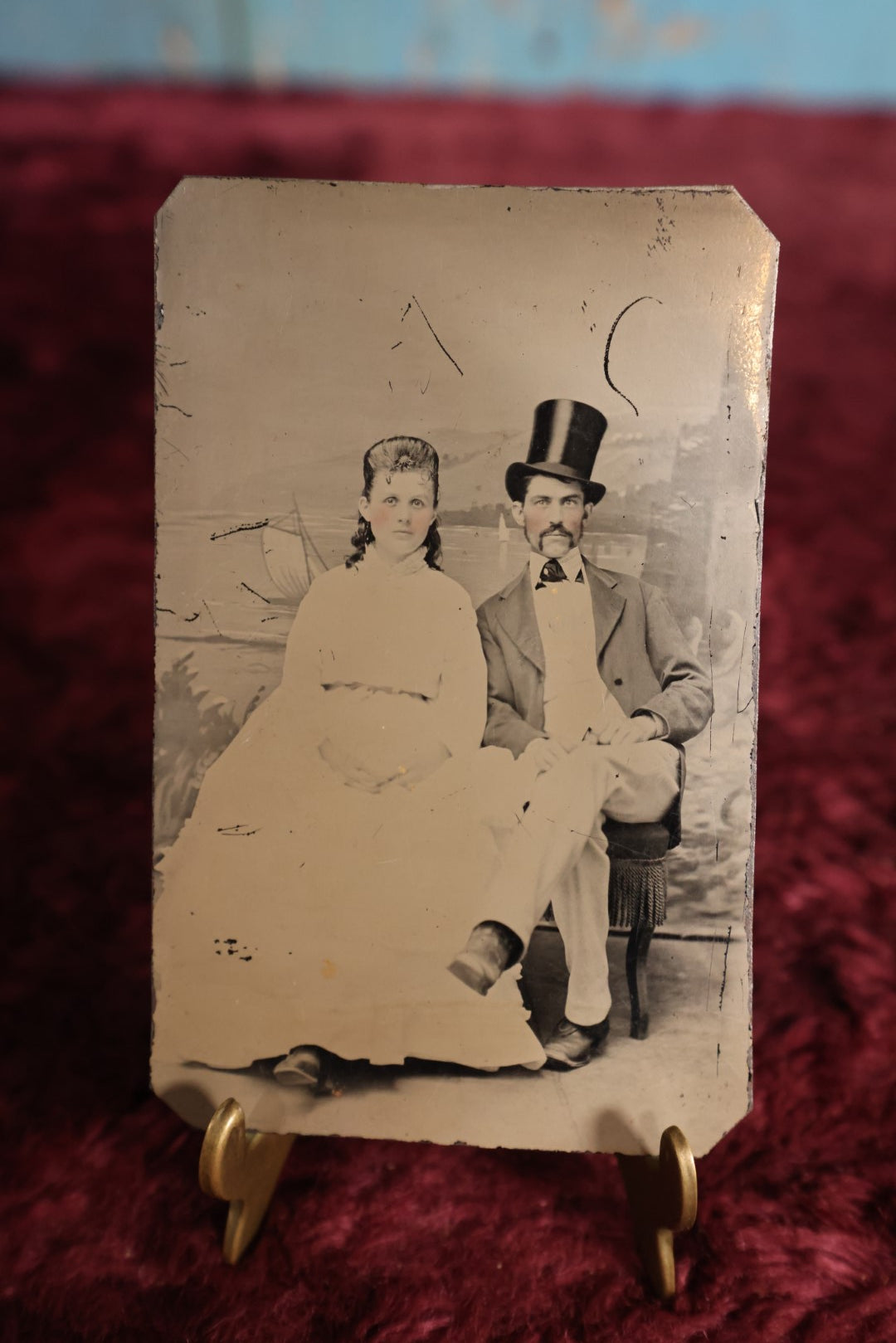 Lot 115 - Tintype - Young Couple With Rosy Cheeks, Woman In White, Man Wearing Tall Stove Pipe Top Hat, White Pants, Legs Crossed