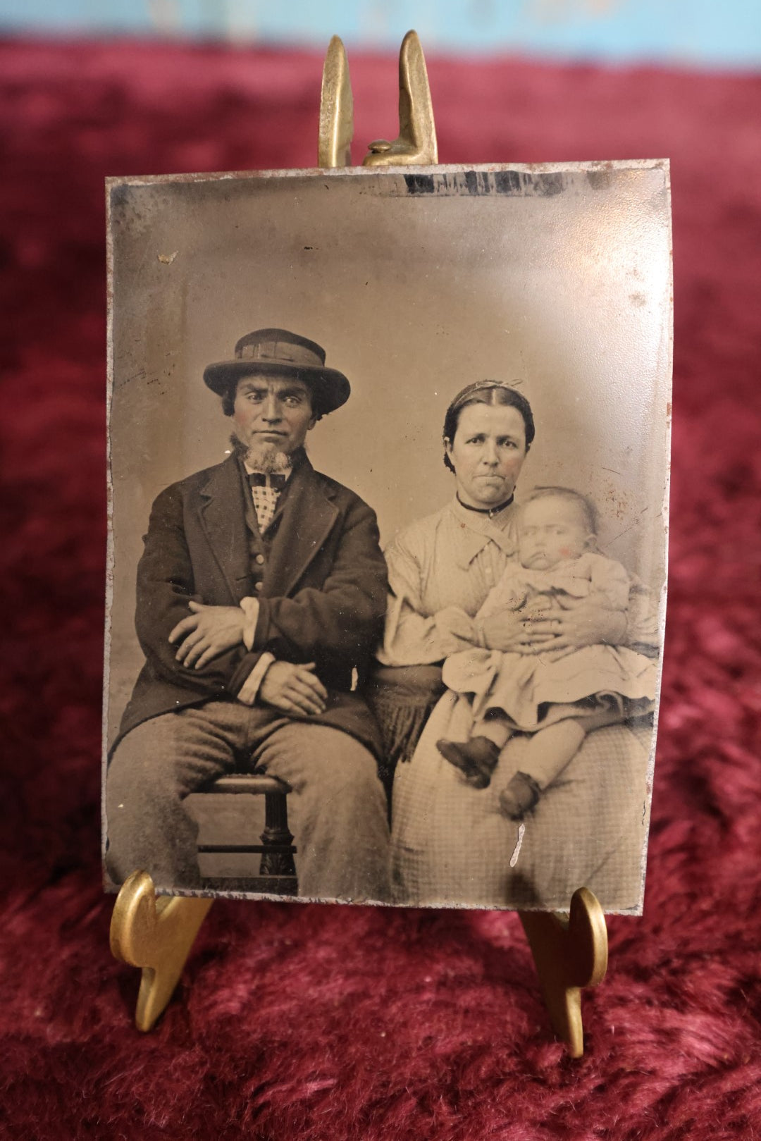 Lot 117 - Tintype - Couple, Man And Woman, Woman Holding Child, Motion Blur In Child's Face, Man Wearing Hat And Of Possible Native Ancestry