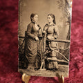 Lot 120 - Tintype - Two Pretty Young Women Standing On Opposite Sides Of Branch Fence Set Piece