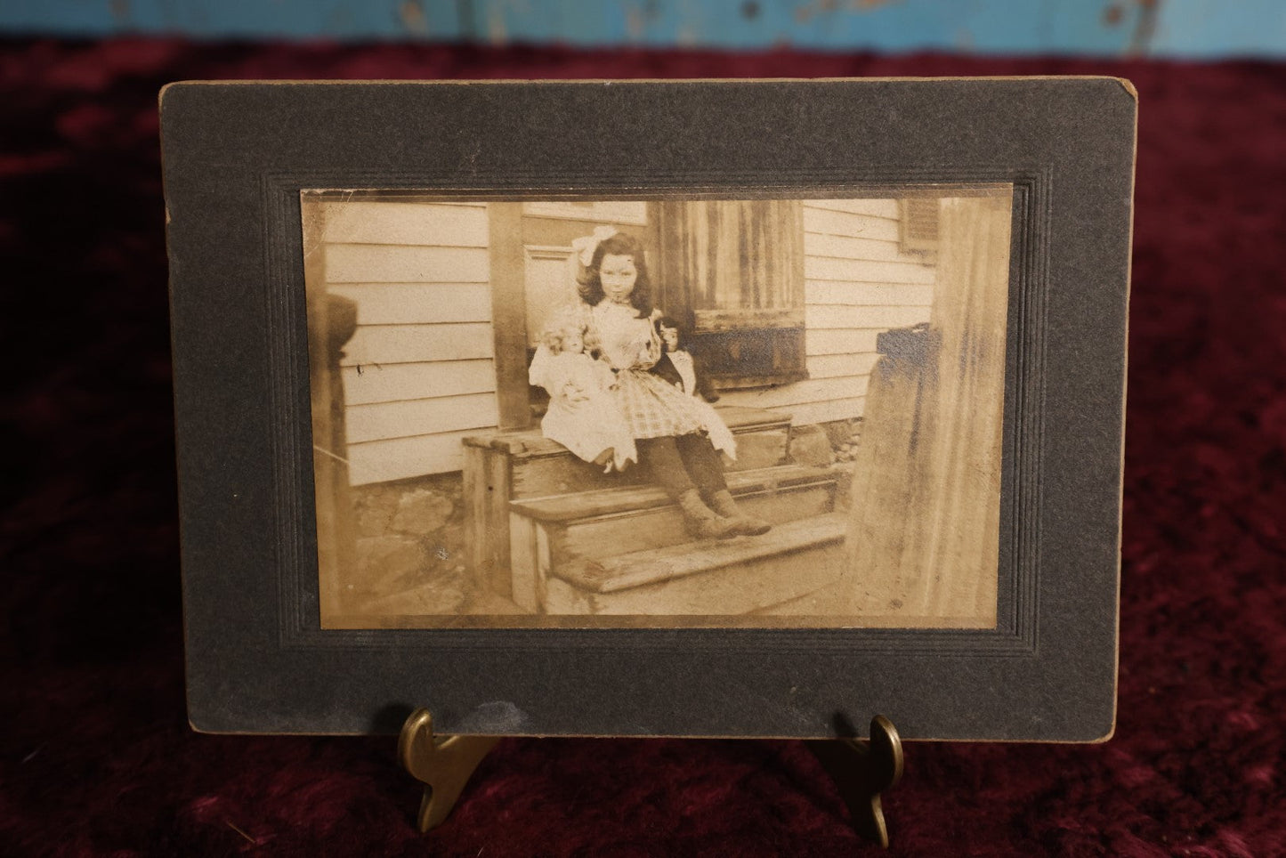 Lot 133 - Small Boarded Photo - Little Girl Sitting On Stoop Holding Two Dolls