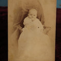 Lot 144 - Cabinet Card - Baby Sitting In Chair, Sucking Thumb, Black Sheet, Identified As Harriet May Hyde, Dec1880, At 6 Months Old, Frank Russell, Photographer, Lawrence, Massachusetts, Ph