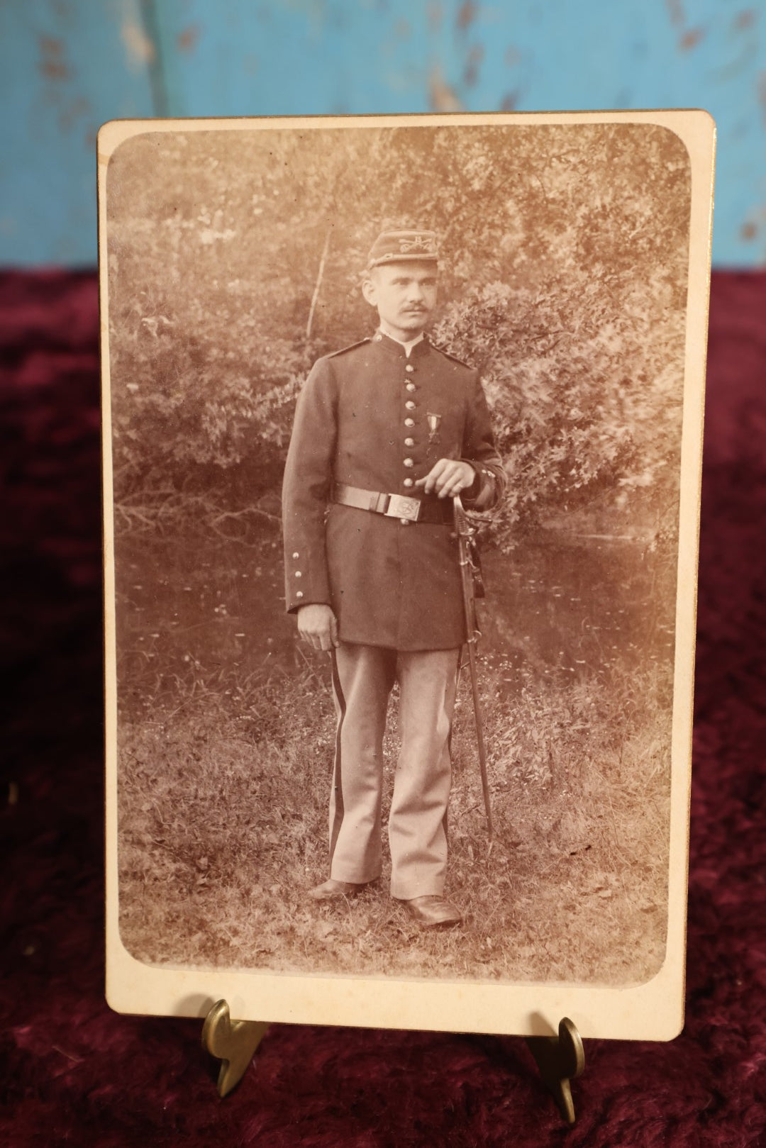 Lot 147 - Cabinet Card - Solder Standing With Hand Resting On Sword Hilt, Cap, Stripe Down Pants, Outdoor Photo, Wearing Medal