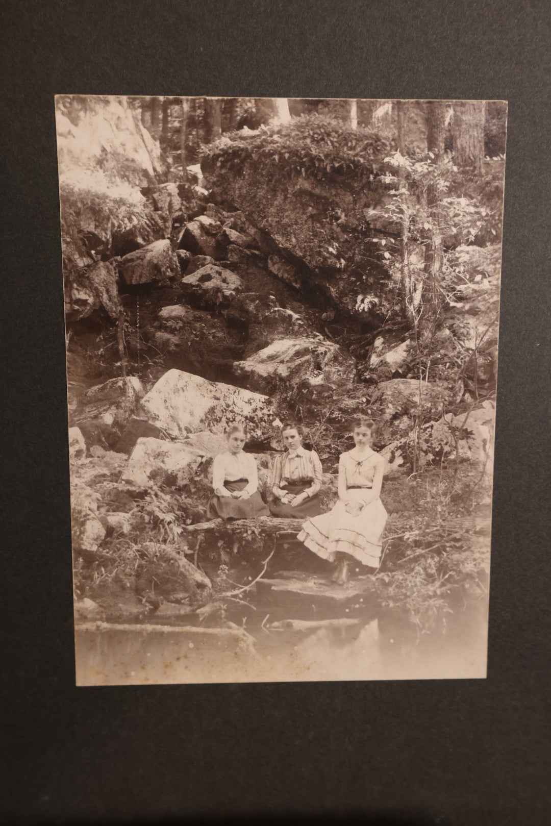 Lot 163 - Boarded Photo - Three Young Girls Sitting At Base Of Rock Fixture, Sitting On Log, Old Furnace, Connecticut, Identified On Back