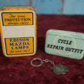 Lot 100 - Three Piece Automotive Transportation Lot - Mazda Lamps Tin, Cycle Repair Outfit Tin With Contents, And Esso Tiger Keychain