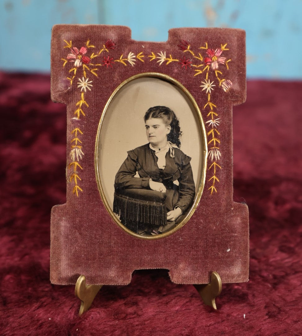 Lot 103 - Antique Velvet Embroidered Frame With Floral Design Containing A Tintype of A Pretty Victorian Woman Leaning On A Chair's Armrest