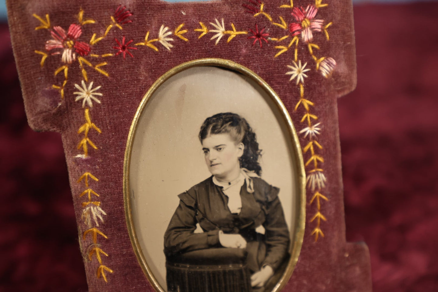 Lot 103 - Antique Velvet Embroidered Frame With Floral Design Containing A Tintype of A Pretty Victorian Woman Leaning On A Chair's Armrest