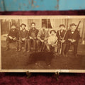 Lot 015 - Antique Boarded Photo Of Seven Men Hunters With Shotguns And Dead Bear Cub, Hunting Interest, Note Man In Window, Back Marked Ella E. Plummer