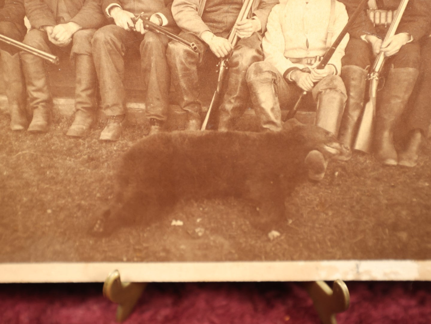 Lot 015 - Antique Boarded Photo Of Seven Men Hunters With Shotguns And Dead Bear Cub, Hunting Interest, Note Man In Window, Back Marked Ella E. Plummer