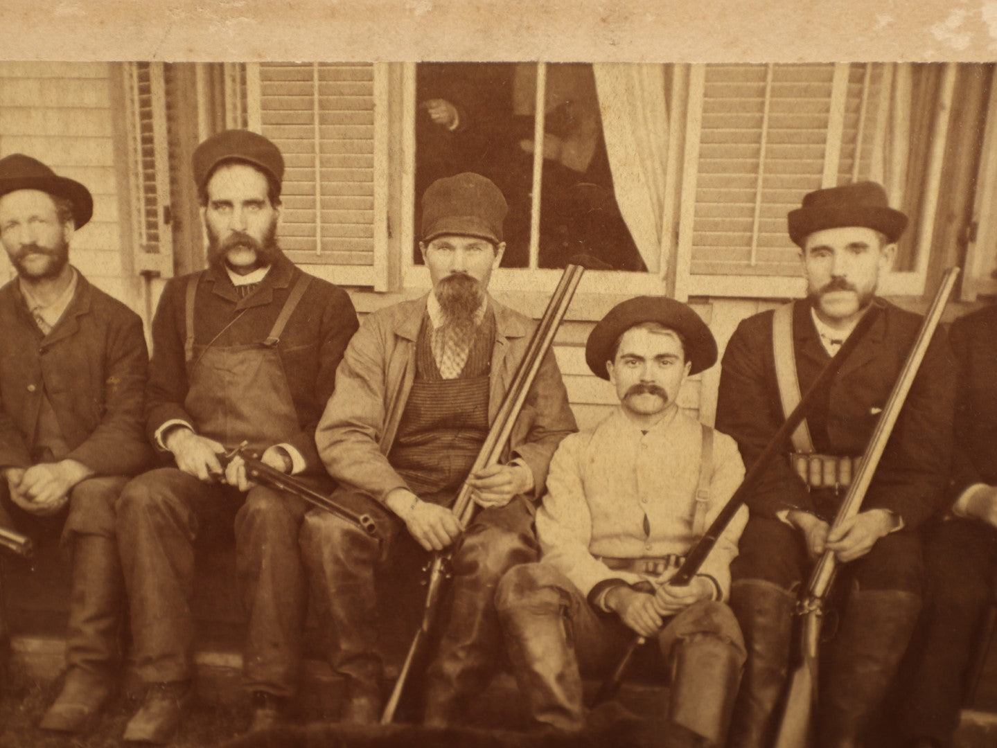 Lot 015 - Antique Boarded Photo Of Seven Men Hunters With Shotguns And Dead Bear Cub, Hunting Interest, Note Man In Window, Back Marked Ella E. Plummer