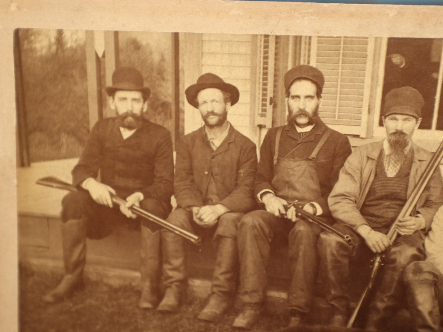 Lot 015 - Antique Boarded Photo Of Seven Men Hunters With Shotguns And Dead Bear Cub, Hunting Interest, Note Man In Window, Back Marked Ella E. Plummer