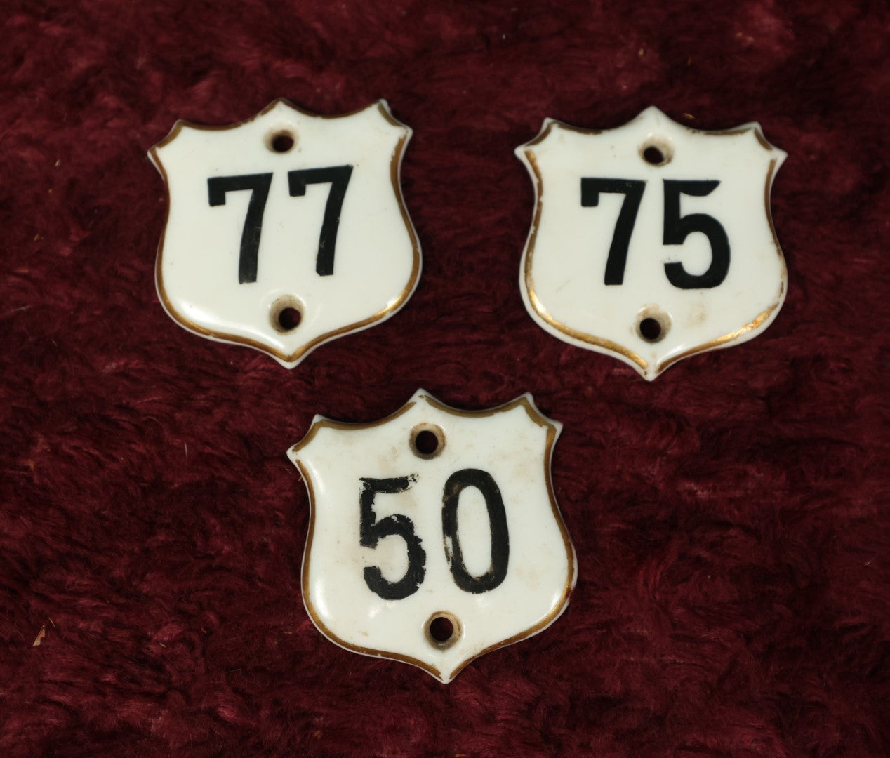 Lot 066 - Grouping Of Three Porcelain Number Badge Shields, Possibly From Hotel, Room Numbers, Including 50, 75, And 77, Various Wear, Paint Losses