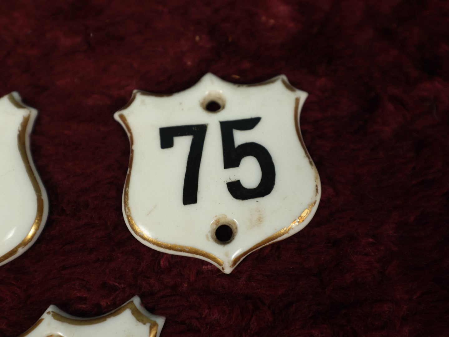 Lot 066 - Grouping Of Three Porcelain Number Badge Shields, Possibly From Hotel, Room Numbers, Including 50, 75, And 77, Various Wear, Paint Losses