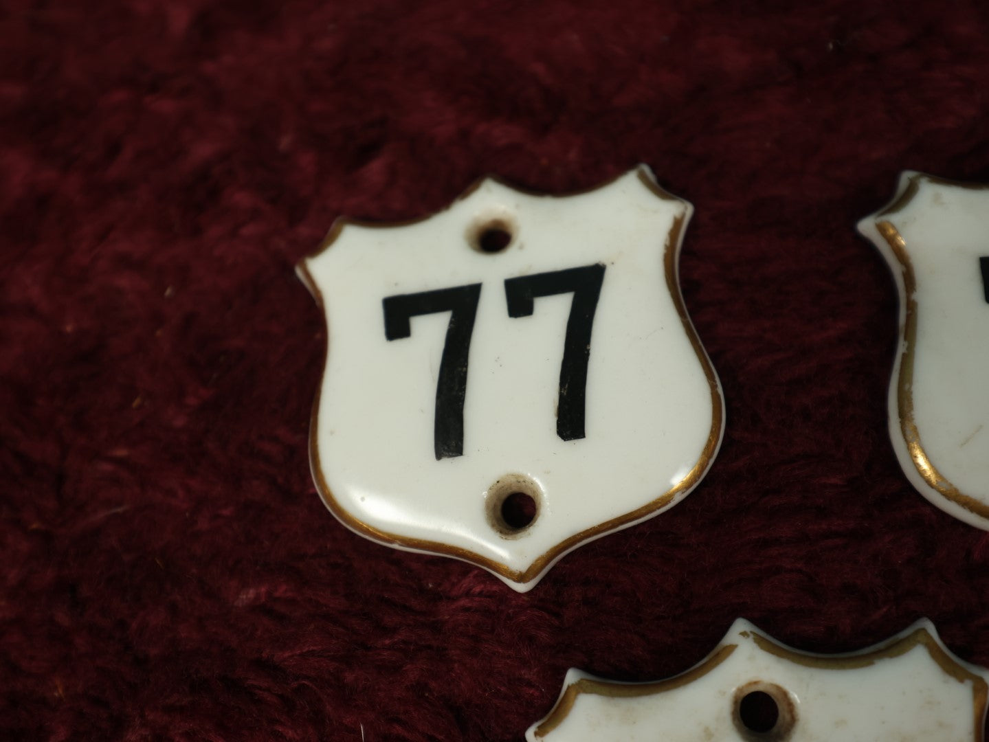 Lot 066 - Grouping Of Three Porcelain Number Badge Shields, Possibly From Hotel, Room Numbers, Including 50, 75, And 77, Various Wear, Paint Losses