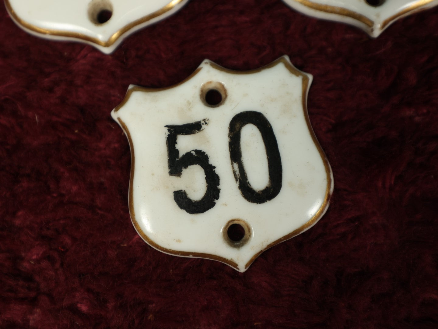 Lot 066 - Grouping Of Three Porcelain Number Badge Shields, Possibly From Hotel, Room Numbers, Including 50, 75, And 77, Various Wear, Paint Losses