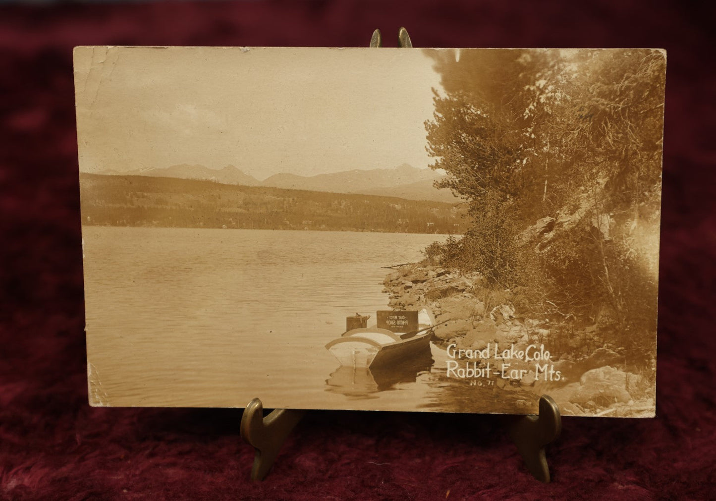 Lot 150 - Single Postcard - RPPC Real Photo Postcard Of Grand Lake Colorado, Rabbit Ear Mountains, Note Suitcase Of Photographer Visible In Boat In Photo, "Out West Photo Studio, Denver," Dated 1913