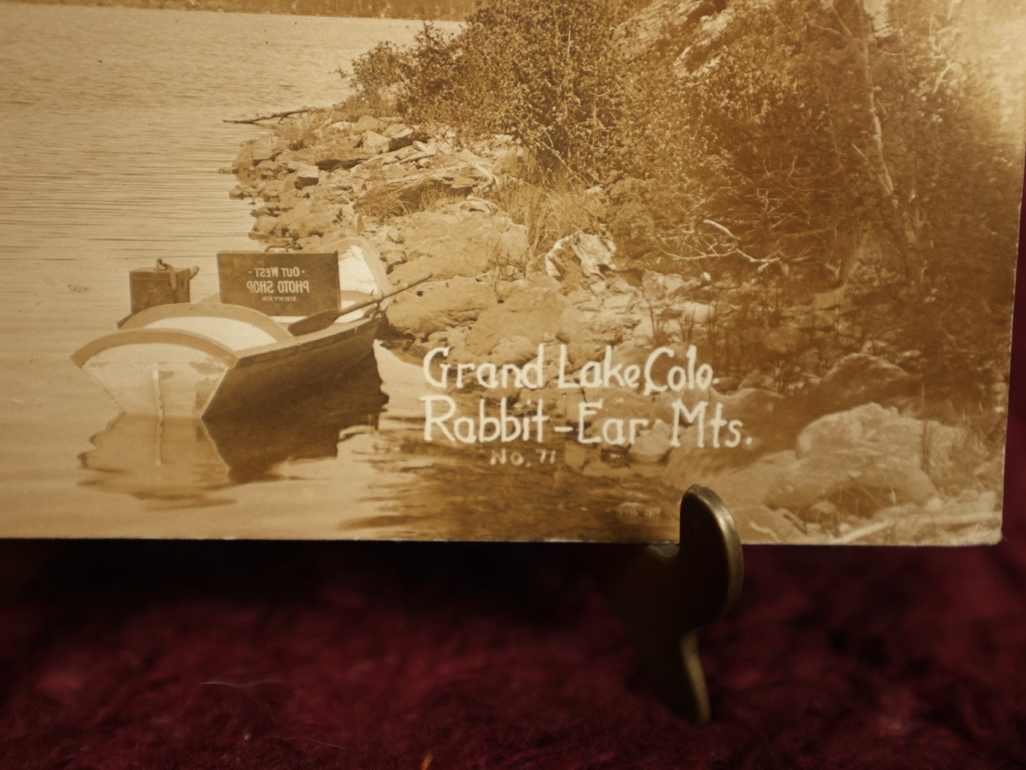 Lot 150 - Single Postcard - RPPC Real Photo Postcard Of Grand Lake Colorado, Rabbit Ear Mountains, Note Suitcase Of Photographer Visible In Boat In Photo, "Out West Photo Studio, Denver," Dated 1913