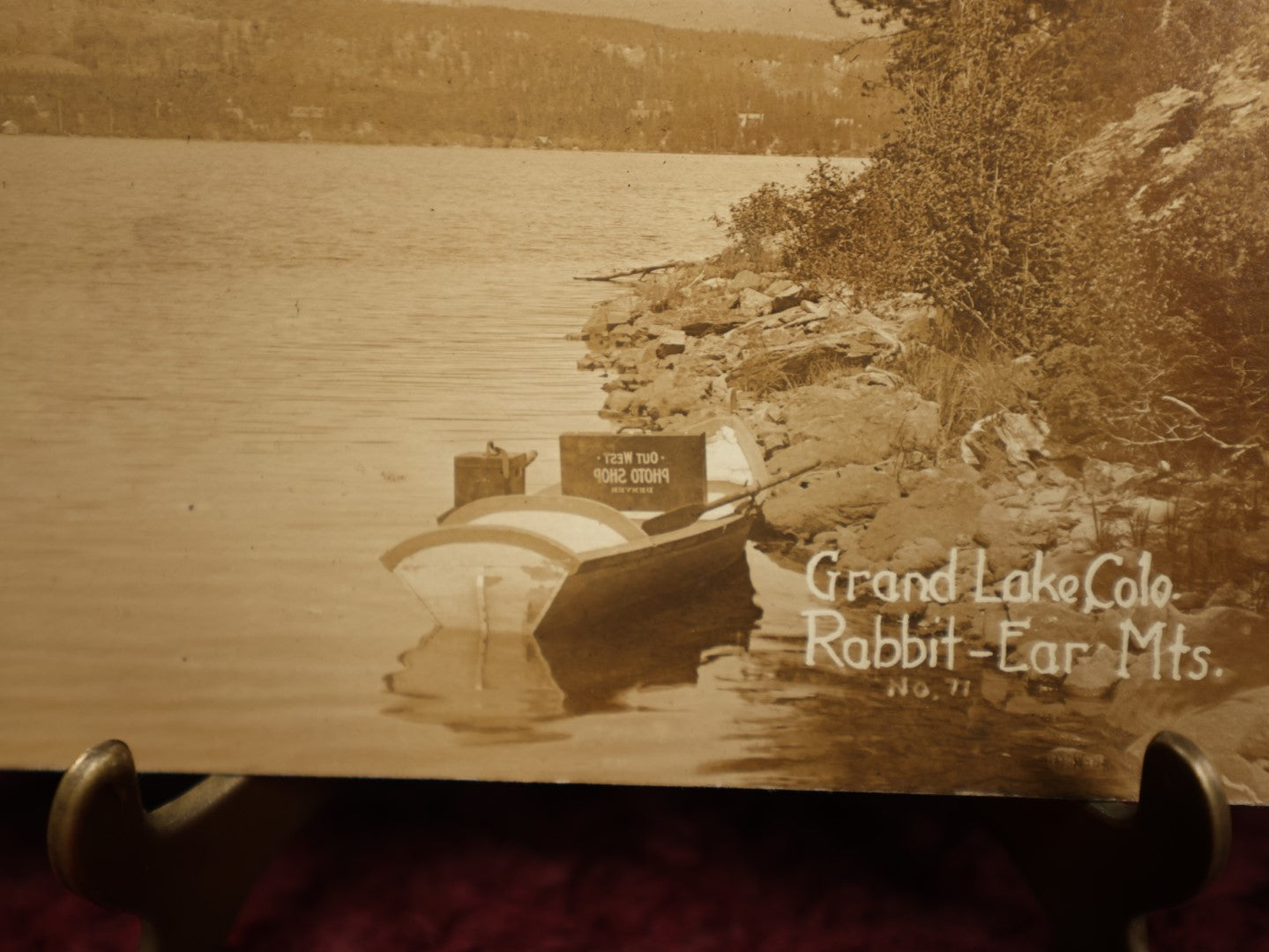 Lot 150 - Single Postcard - RPPC Real Photo Postcard Of Grand Lake Colorado, Rabbit Ear Mountains, Note Suitcase Of Photographer Visible In Boat In Photo, "Out West Photo Studio, Denver," Dated 1913