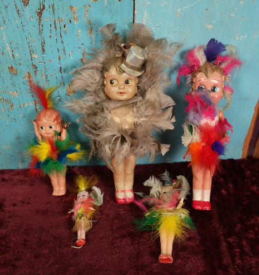 Lot 023 - Grouping Of Five Vintage Celluloid Kewpie-Like Dolls With Elaborate Feathers, Varying Damage, One Lot One Money, Made In Japan, Occupied Japan