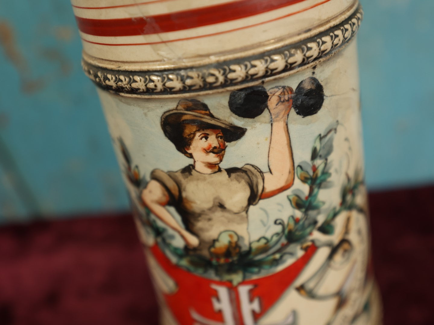 Lot 047 - Antique Hand Painted German Strong Man Stein With Weight Lifter, Metal Top, Two Liter, Note Heavy Damage, Repairs, Wear, Cracking